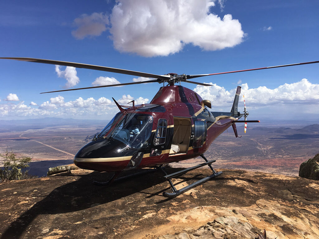 The sleek exterior of the Agusta 119KX MKII helicopter on an airfield.