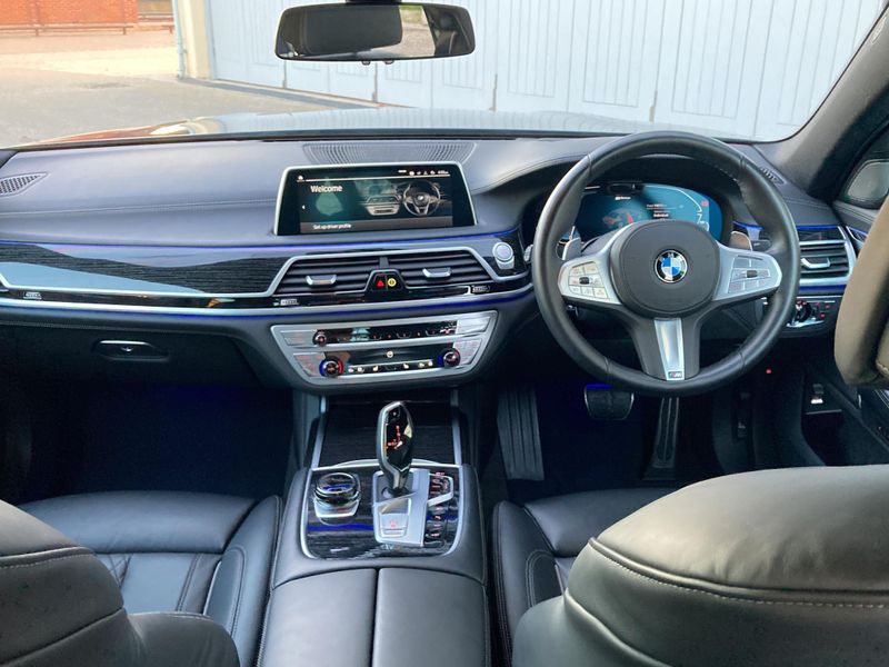 Interior view from the driver's seat of a BMW 7 Series, highlighting the dashboard.