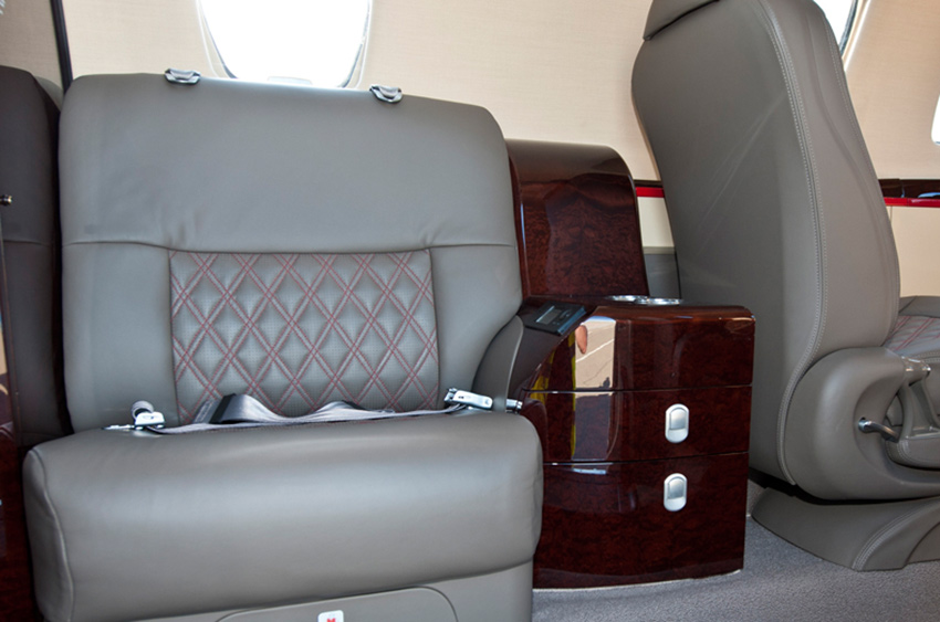 View of the classic interior of a Citation CJ4, showing seating and windows.
