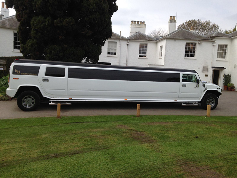 A white Hummer Limo parked, ideal for festive group travel and Christmas parties.